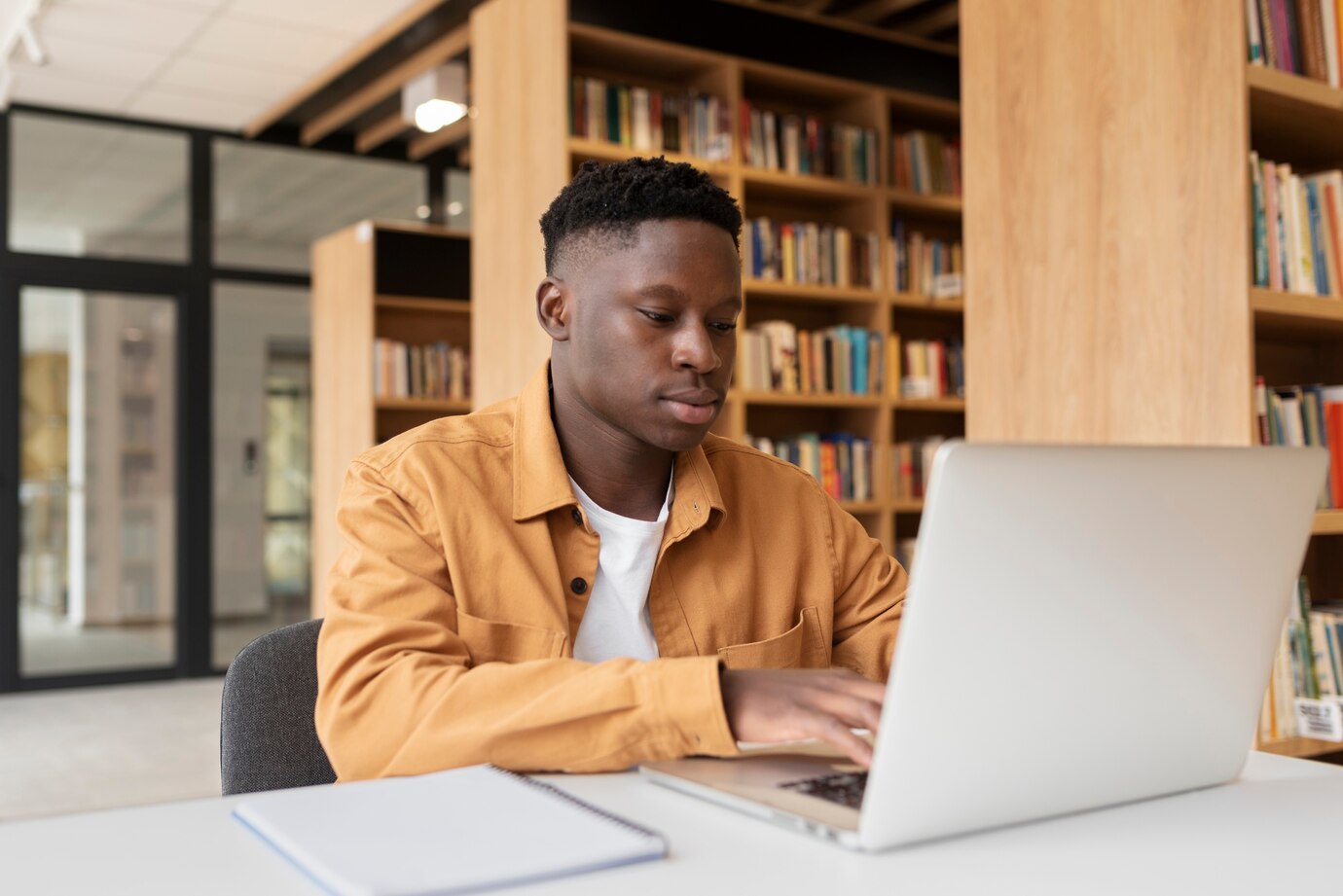 jeune-etudiant-apprenant-dans-bibliotheque_23-2149215451